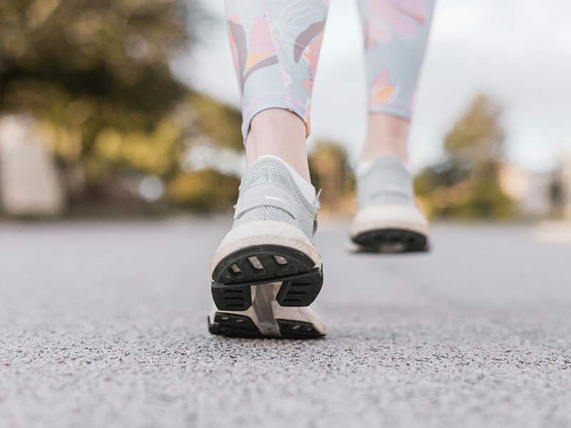 Athlete sneakers showing how to self treat lower back sprain with backwards walking
