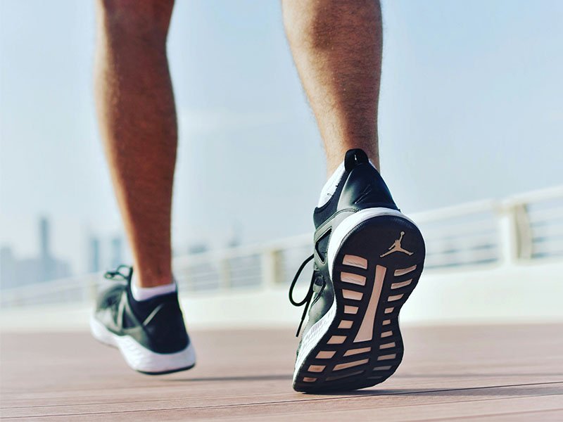 Athletic man walking in shorts and sneakers